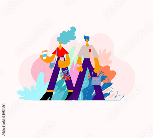 Young man and woman are walking together. The couple is walking, drinking coffee and talking. Stylishly dressed people on the street