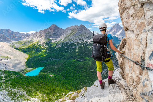 Girl on via ferrata above Sorapis lake in Dolomites mountains, Italy, Europe