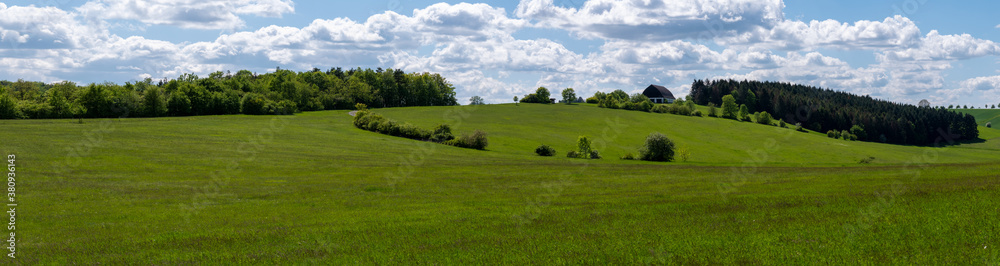 Panorama einer fränkischen Landschaft mit Scheune und Wald im Frühling
