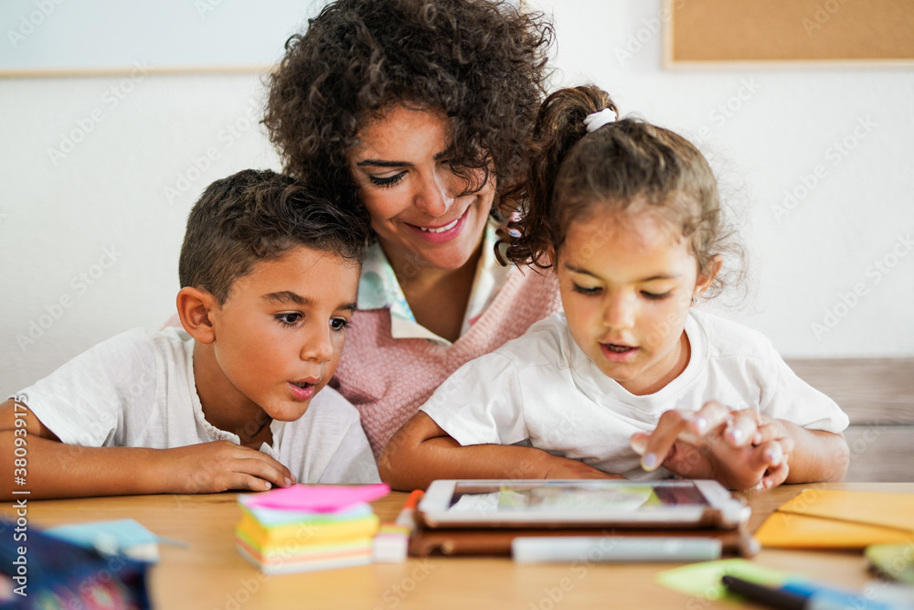 Mother teaching children at home in time of coronavirus - Learning with digital tablet Mother teaching children at home in time of coronavirus - Learning with digital tablet