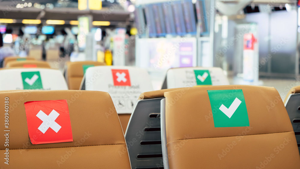 Social distancing, Rows of empty chairs in an airport's departure area marked with symbols regarding social distancing protocol to prevent the spreading of novel corona virus, COVID-19 in Thailand Social distancing, Rows of empty chairs in an airport's departure area marked with symbols regarding social distancing protocol to prevent the spreading of novel corona virus, COVID-19 in Thailand