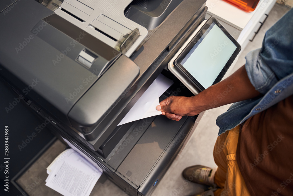 Man holding paper while using photocopy machine Man holding paper while using photocopy machine