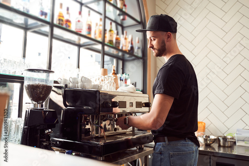 Male barista working on coffee machine