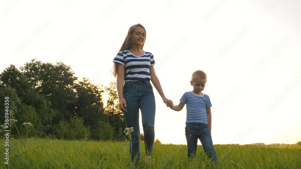 Family walks in the park. Two children sister and brother hold hands in the park. Sister extends helping hands to the baby. Happy family daydreaming outdoors. Childhood dream concept. Family walks in the park. Two children sister and brother hold hands in the park. Sister extends helping hands to the baby. Happy family daydreaming outdoors. Childhood dream concept.