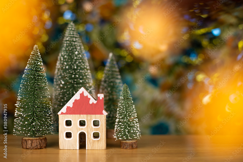 Christmas trees and house on wood table with bokeh background. Christmas holiday celebration and new year concept Christmas trees and house on wood table with bokeh background. Christmas holiday celebration and new year concept