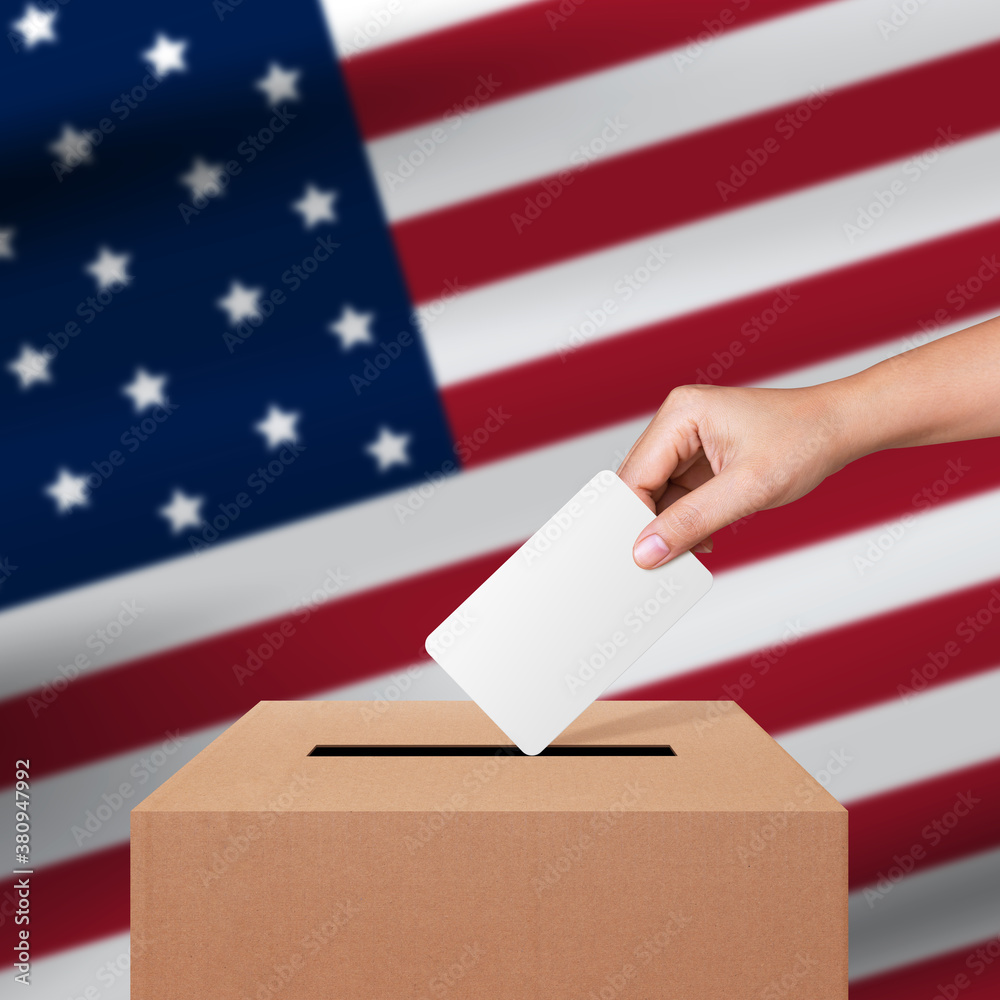 Woman hand putting voting ballot into vote box on flag of USA. Voting concept Woman hand putting voting ballot into vote box on flag of USA. Voting concept
