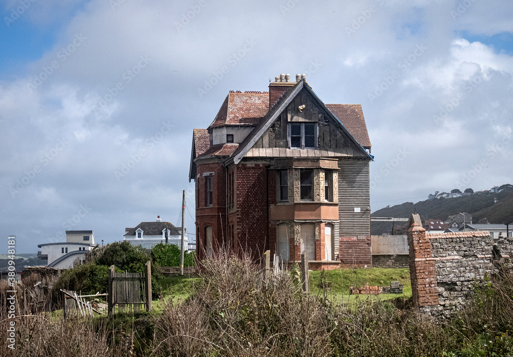 Abandoned building on cliff edge slowly being eroded and falling into the sea. Abandoned building on cliff edge slowly being eroded and falling into the sea.