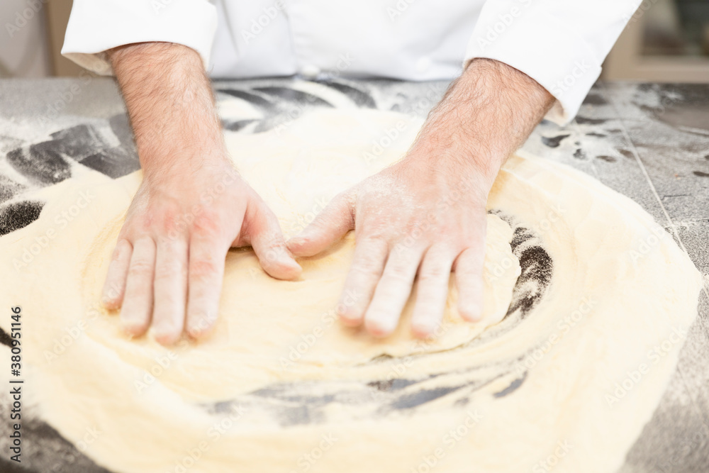 Traditional Italian cuisine: chef prepares pizza dough with water and flour. food photography for menus and websites