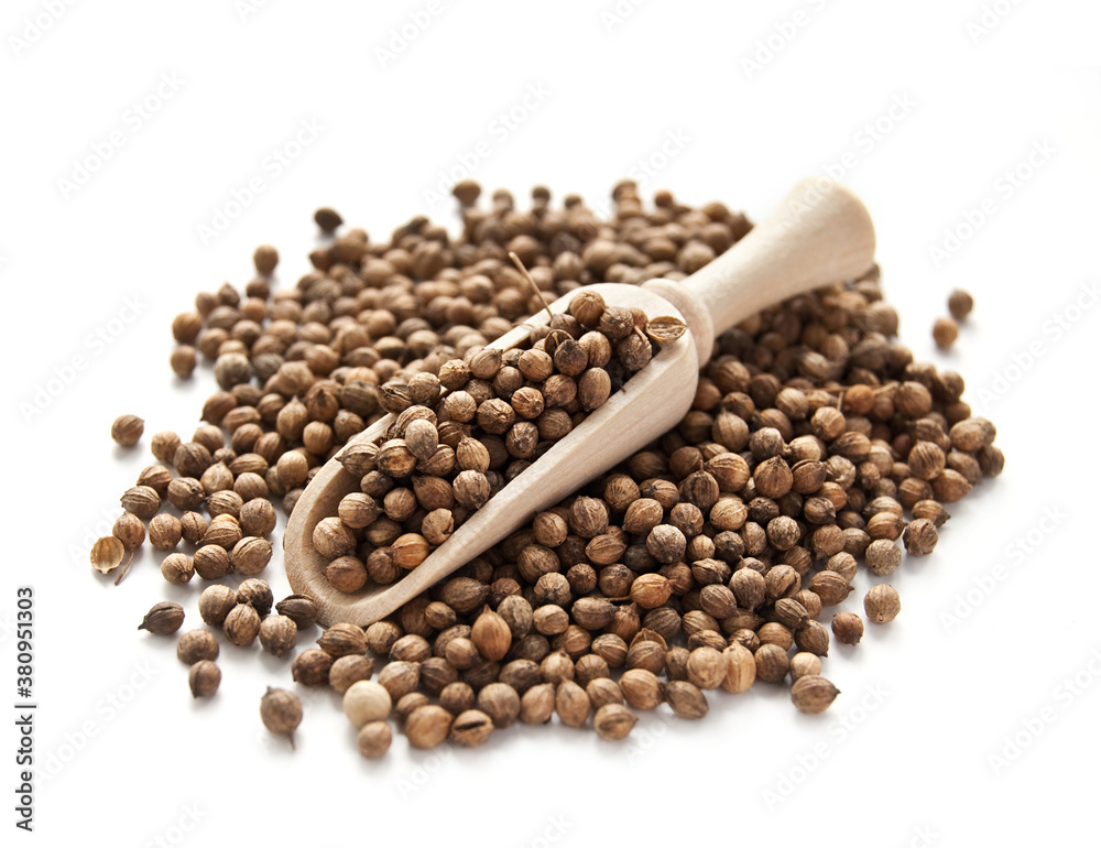 Wooden shovel with coriander seeds on white background Wooden shovel with coriander seeds on white background