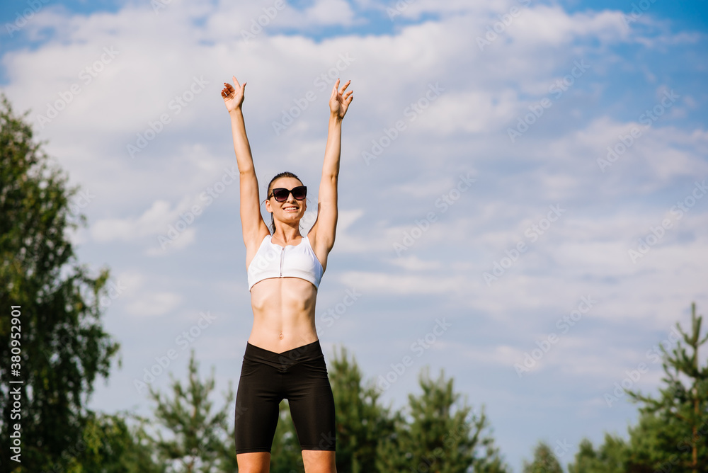 Young slim fit woman doing sport exercise outdoors in the park at the sunny day Young slim fit woman doing sport exercise outdoors in the park at the sunny day