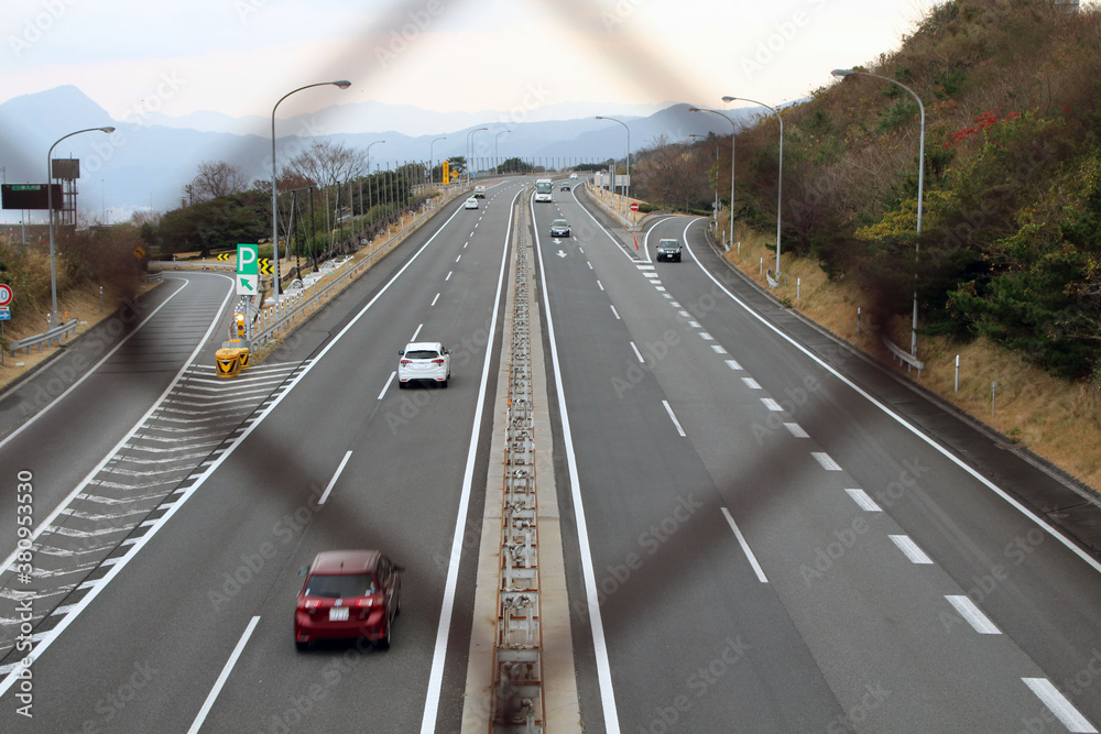 Blurred fence overlooking Japanese highway, taken in Beppu