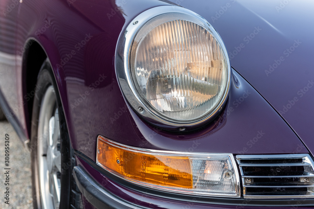 Front headlight shines bright for this purple automobile that was built purely for speed and fun.