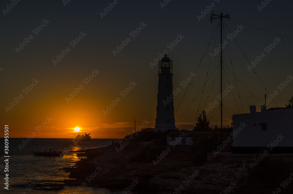 Crimea, lighthouse silhouette against the sunset in the sea, Cape Tarkhankut