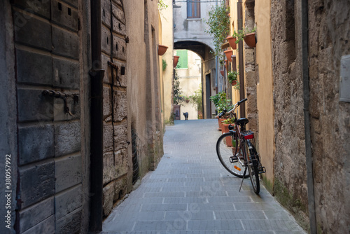 Vintage narrow street of Pitigliano, town in Tuscany, Italy. Cat walking by. Selective focus. 