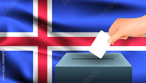 Male hand puts down a white sheet of paper with a mark as a symbol of a ballot paper against the background of the Iceland flag. Iceland the symbol of elections