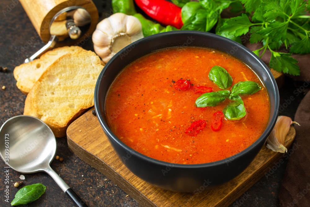Vegan healthy food. Tomato soup or gazpacho on a dark stone or slate table. Vegan healthy food. Tomato soup or gazpacho on a dark stone or slate table.