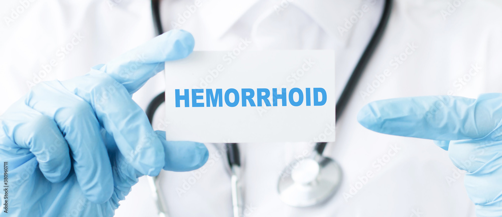 Doctor holding a tablet pc with hemorrhoid sign on blue background Doctor holding a tablet pc with hemorrhoid sign on blue background
