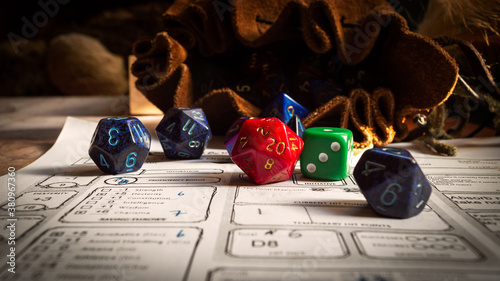 Close up of spilling out dice of different kinds from a dice bag on a character sheet.