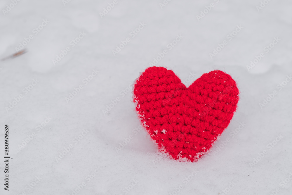 Knitted Red heart on the snow. Background Valentine's day , place for text, love heart. Winter flat lay