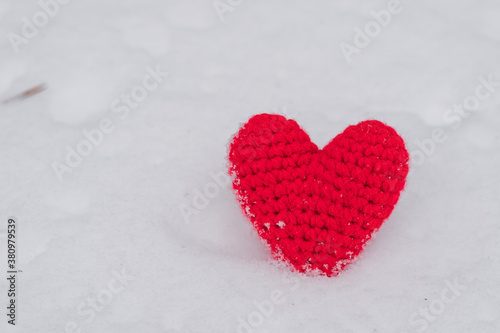 Knitted Red heart on the snow. Background Valentine's day , place for text, love heart. Winter flat lay