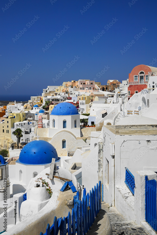 Blue fence, winding streets and beautiful buildings in Santorini