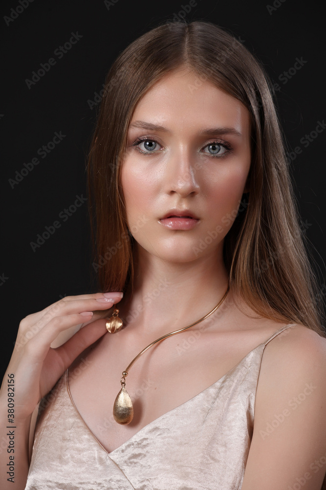 Fashion beauty model, professional makeup and beautiful gold jewelry, posing in studio, isolated on black