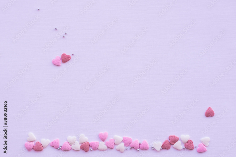 Candies hearts on pink and white paper. Flat lay for Valentine’s Day. Creative sweet concept. Background, top view