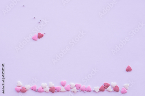 Candies hearts on pink and white paper. Flat lay for Valentine’s Day. Creative sweet concept. Background, top view © Iryna