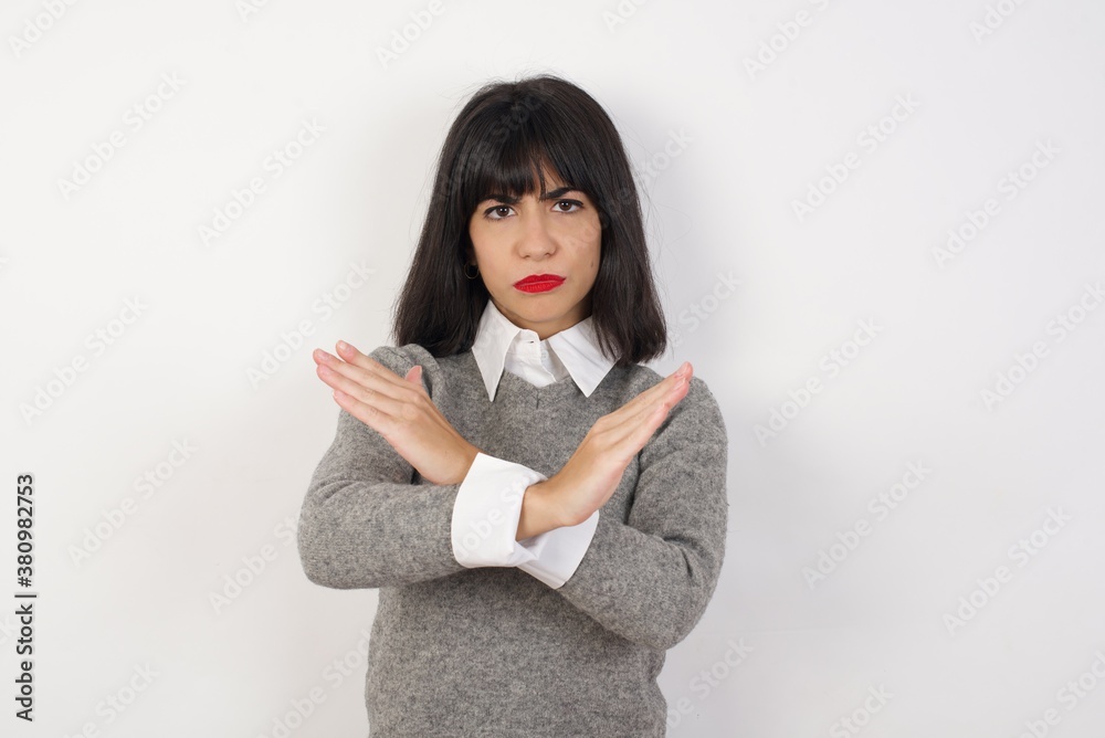 Young businesswoman with retro short hair wearing casual clothes standing over isolated white background Rejection expression crossing arms doing negative sign, angry face Young businesswoman with retro short hair wearing casual clothes standing over isolated white background Rejection expression crossing arms doing negative sign, angry face
