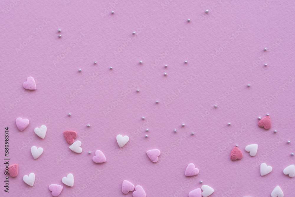 Candies hearts on pink and white paper. Flat lay for Valentine’s Day. Creative sweet concept. Background, top view Candies hearts on pink and white paper. Flat lay for Valentine’s Day. Creative sweet concept. Background, top view