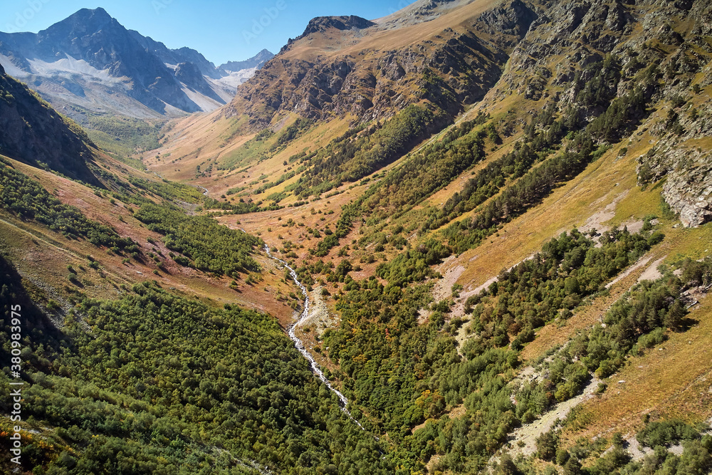 Majestic mountains covered with trees and beautiful mountain river. Aerial view in the mountains on a green forests. View on the river between mountain forest