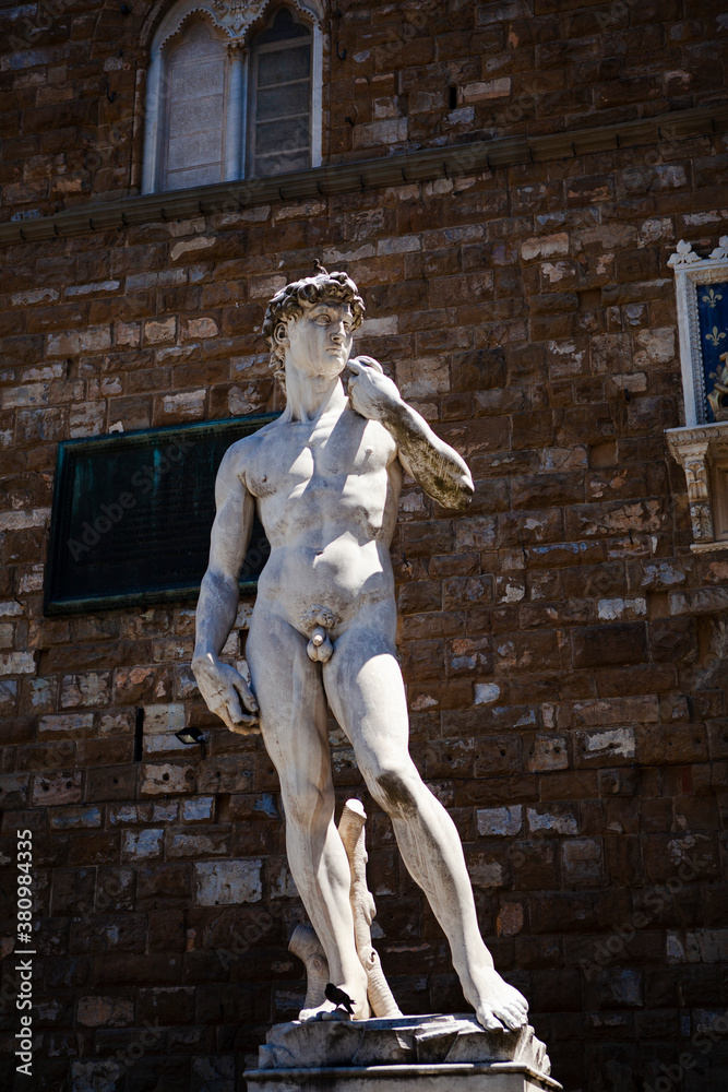 Obraz premium The Italian Renaissance sculpture of The David created in marble by the Italian artist Michelangelo in Florence, Tuscany, Italy. Close up street view. European art and outdoor decor.