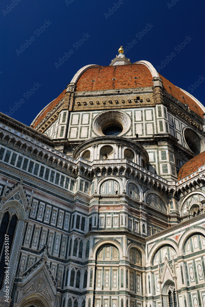 Looking up to Duomo in Florence with the red dome against a deep blue sky