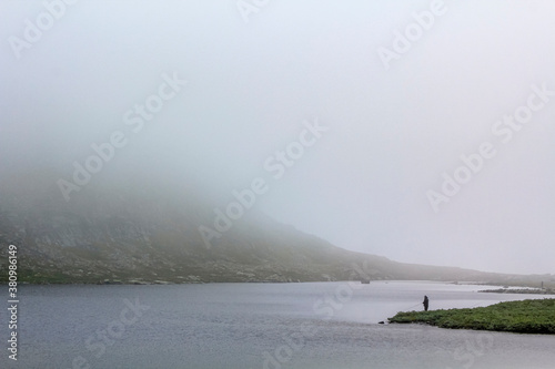 Fisher fishing in the Horntjerni lake river on Veslehødn, Norway. photo