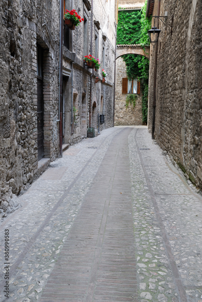 Empty stone alleyway leading to a window in Spoleto Italy