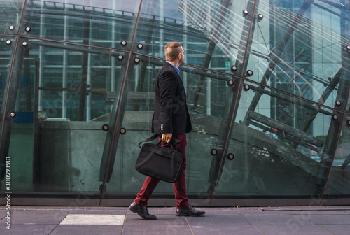 Photo of a young and attractive business man wearing smart clothes with a briefcase ready to start his work day