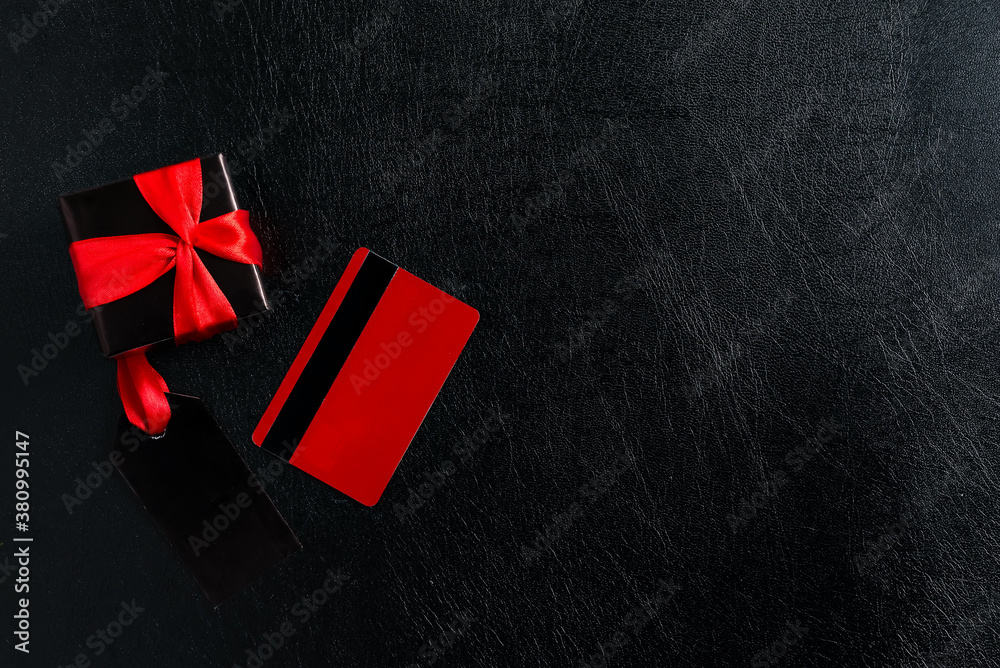 Obraz premium Black label, credit card and gift box on a dark leather.
