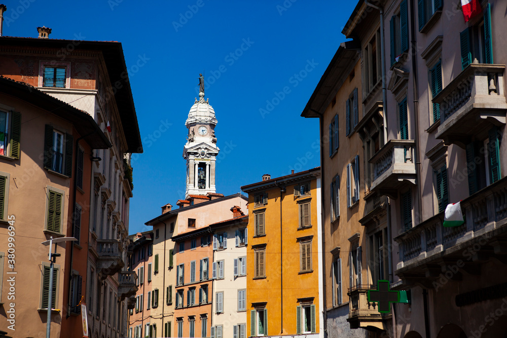 Close up. The street view of the old Italian colorful buildings with wooden shutters, tiled roofs, towers, shops in the city center of Bergamo, Lombardy, Italy. Vintage European architecture.