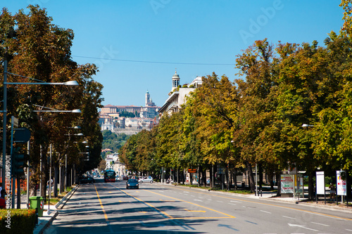 Bergamo, Lombardy / Italy - September 01, 2020 - Urban view. Classic Italian street in the middle of the city center with cars, trees, vintage buildings. European architecture.