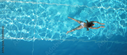 Sporty woman swimming in a pool - view from above