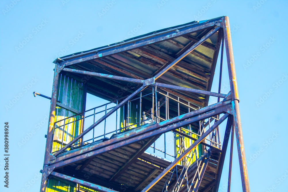 industrial old fire tower on blue sky background