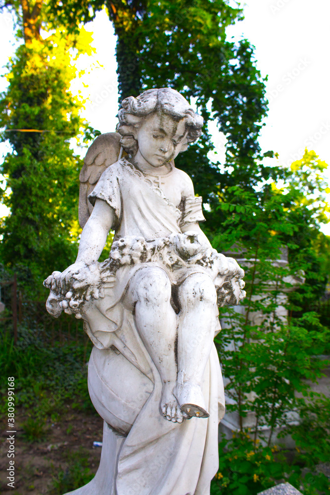 Figure of a praying angel. A very ancient stone statue. Death. Sad angel as symbol of pain, fear and end of life. Figure of a praying angel. A very ancient stone statue. Death. Sad angel as symbol of pain, fear and end of life.