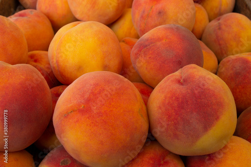 Beautiful yellow-red ripe peaches in a box.