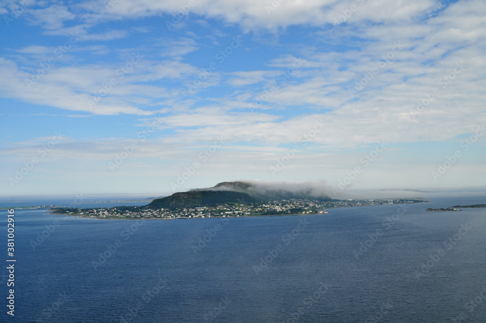 A small island in the morning clouds in the middle of the open sea (Norway)