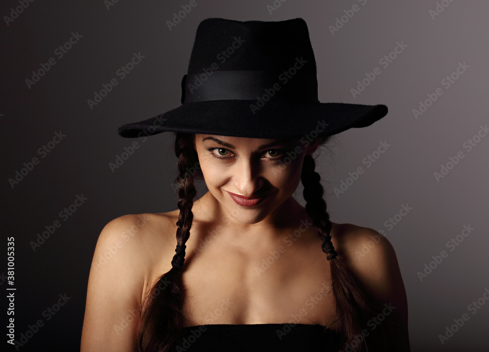 Beautiful fun positive young woman in style blue hat smiling on dark shadow background. Closeup portrait. Halloween Beautiful fun positive young woman in style blue hat smiling on dark shadow background. Closeup portrait. Halloween