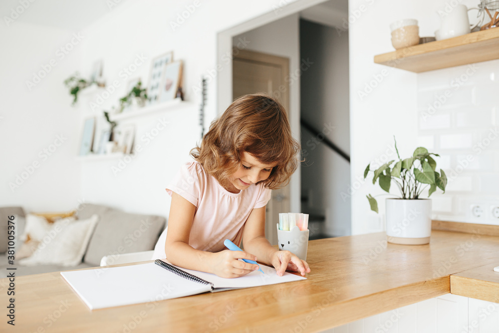 Cute happy little girl, adorable preschooler, 5 years child painting at the table in a white living room at home. Cute happy little girl, adorable preschooler, 5 years child painting at the table in a white living room at home.