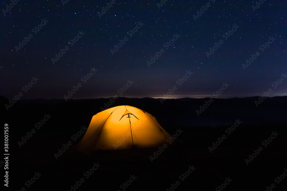 Tent under the starry sky at night.