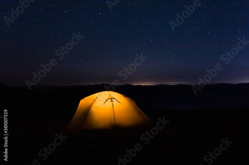 Tent under the starry sky at night.