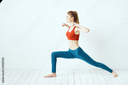 athletic woman in pose on the floor exercise gymnastics performance light background