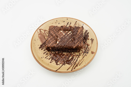 White chocolate brownie slice on plate over white background